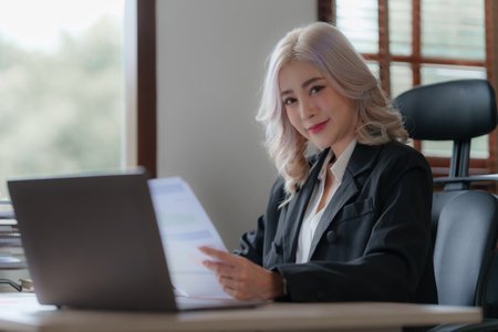 Bookkeeper or financial inspector auditing many financial document at officeの写真素材