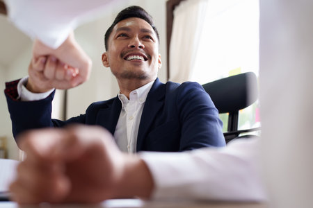 Group of business people putting their hands working together on wooden background in office. group support teamwork agreement conceptの写真素材