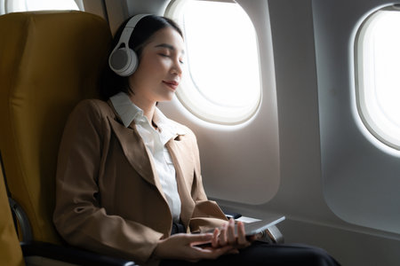 Asian Business woman sleeping in the airplane while flight go to meet clientの写真素材