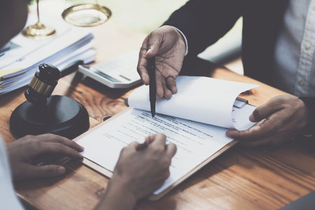 Business woman and lawyers discussing contract papers with brass scale on wooden desk in office. Law, legal services, advice, Justice conceptの写真素材