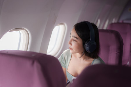 Young asian woman wear headphones for noise cancellation search songs in online shop on app during...