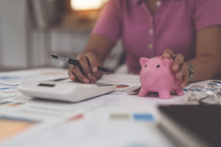 Asian Businesswoman calculating saving account balance with calculator, account and saving conceptの写真素材