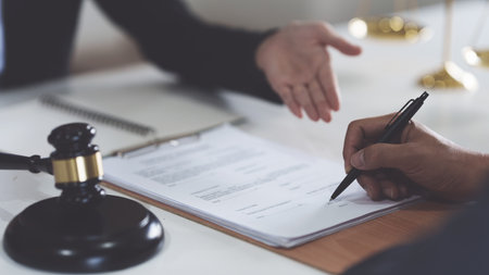 Business woman and lawyers discussing contract papers with brass scale on wooden desk in office....