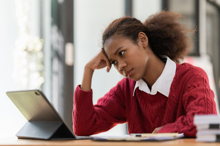 Portrait of stressed young black woman using digital tableの写真素材