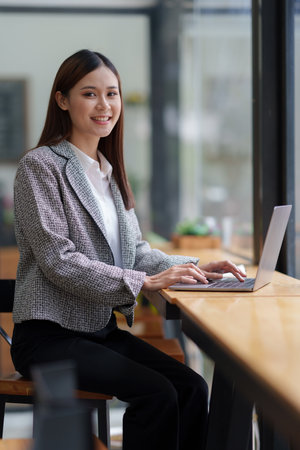 Asian Business woman working to analyze technical price graph and indicator with business team talking by cell phone. account or saving money or insurance conceptの写真素材