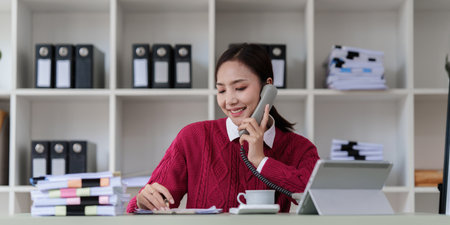 Pleasant positive business woman using digital tablet at home officeの写真素材