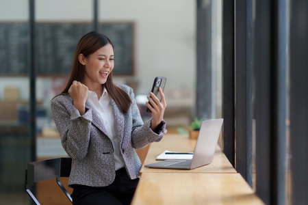 Portrait of Happy Asian woman talking with friend by cell phoneの写真素材