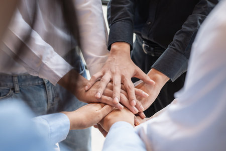 Group of business people putting their hands working together on wooden background in office. group support teamwork agreement conceptの写真素材