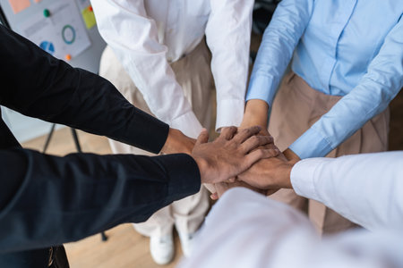 Group of business people putting their hands working together on wooden background in office. group...