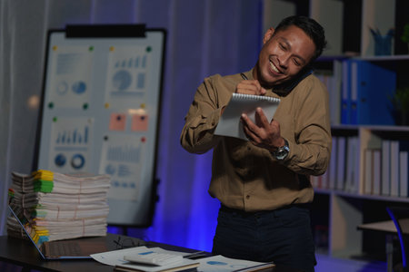 Stressed business man working over time at night. business account and finance conceptの写真素材