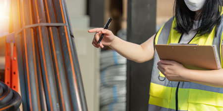 Working at warehouse. Male warehouse worker checking in storage department. Employee organizing goods distribution to the market.の写真素材