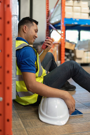 Working at warehouse. Male warehouse worker checking in storage department. Employee organizing...