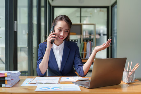 Female employee using laptop at workplace. Businesswoman preparing economic report by laptop computerの写真素材