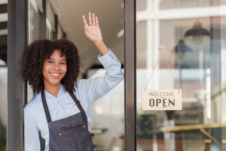 Young Female manager in restaurant with notebook. Woman coffee shop owner with open sign. Small...