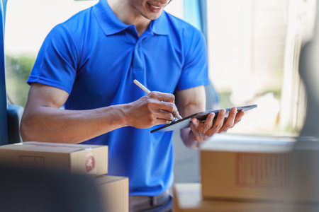 Asian courier with parcel and delivery logistic concept. Delivery man using digital tablet
