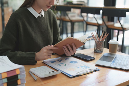 Asian Business woman working at home office and analyze financial report document. Accounting and Finance conceptの写真素材