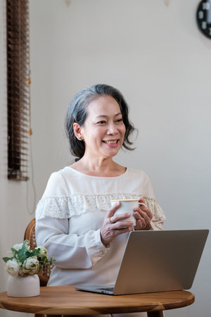 Smart asian mature middle-aged businesswoman CEO boss leader teacher using laptop, e-learning ,...
