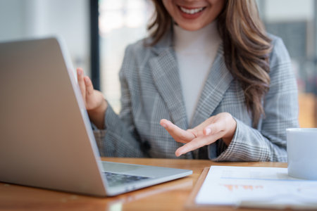 Smiling asian business woman with laptop computer in office. Woman in suit at officeの写真素材