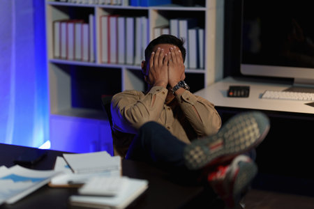 Stressed business man working over time at night. business account and finance conceptの写真素材