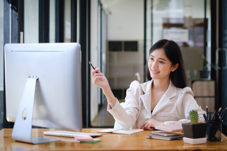 Asian Woman blogger wear white suit talking with followers, live streaming on social media application. Freelance work from home concept.の写真素材