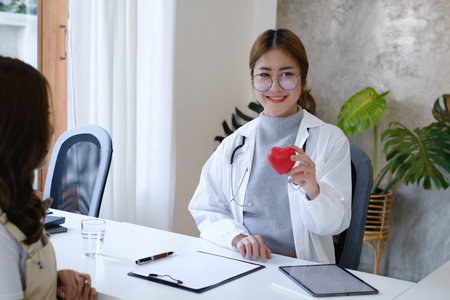 Cardiologist holding red heart in private clinic. Medical technology diagnostics of heart concept.の写真素材
