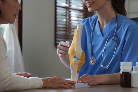 Professional Doctor explain on area of model knee joint at clinic. medical and orthopedic conceptの写真素材