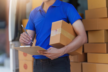 Asian courier with parcel and delivery logistic concept. Delivery man using digital tablet