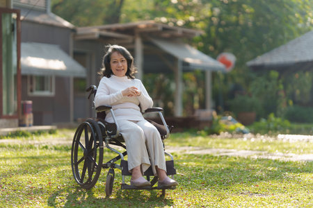 Happy senior asian women in wheelchair at home garden.の写真素材