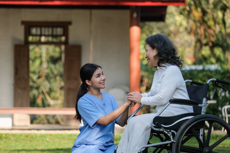 Elderly asian senior woman on wheelchair with nurse. Nursing home hospital garden concept.の写真素材
