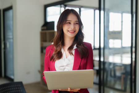Beautiful asian business woman working on a laptop at office. Financial analysis and tax conceptの写真素材