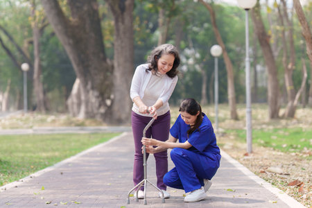 Healthcare nurse, physical therapy with elderly woman at outdoor. Nurse holding hand and help elderly womanの写真素材