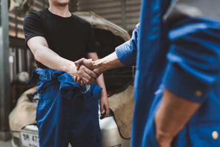 Expert auto mechanic handshake and working together at garage. automobile car conceptの写真素材