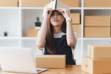 Small businesses SME owners female entrepreneurs check online orders to prepare to pack the boxes, sell to customers, sme business ideas onlineの写真素材