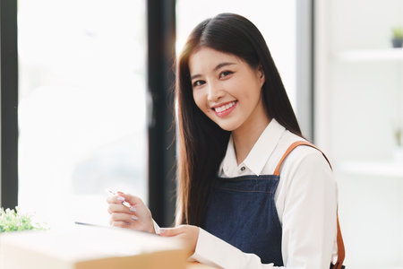 Small businesses SME owners female entrepreneurs check online orders to prepare to pack the boxes, sell to customers, sme business ideas onlineの写真素材