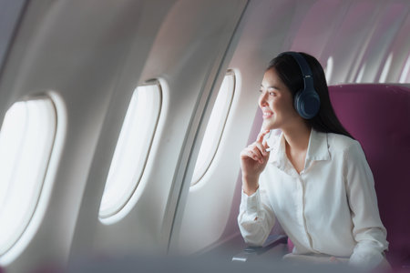 Beautiful Asian businesswoman working with digital tablet in aeroplane. working, travel, business...