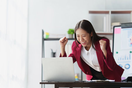 Asian Business person happy while reading email have a good news in laptop computer. business finance and technology conceptの写真素材