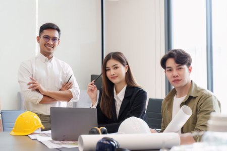 Architect and Engineer working with blueprints for architectural plan, engineer sketching a construction project, green energy conceptの写真素材