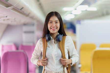 Beautiful Asian traveler woman with backpack when flight is landing. Travel, Airplane conceptの写真素材