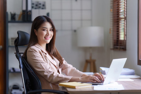 Asian Business person makes analysis and research financial report at office, analyzes profits. Accountant checks status of financialの写真素材