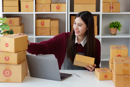 Small businesses SME owners female entrepreneurs check online orders to prepare to pack the boxes,...