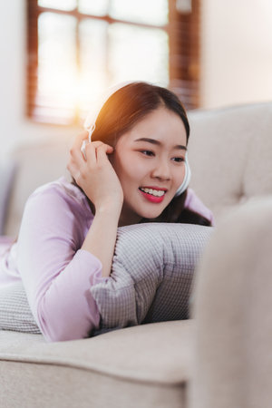 Attractive Asian woman resting comfortable living room and using mobile phone, Relax, Sofa, Lifestyleの写真素材