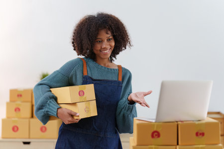 American African entrepreneur smile and checking online order. Successful SME entrepreneur concept