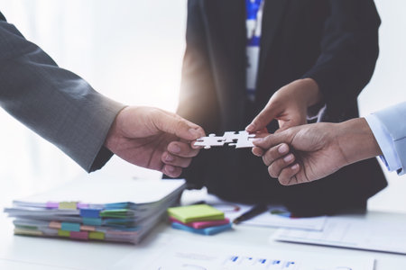 Group of business people putting their hands working together on wooden background in office. group...