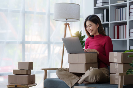 Small businesses SME owners female entrepreneurs check online orders to prepare to pack the boxes,...