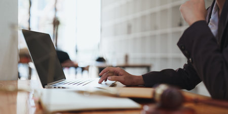 Young lawyer in office Business woman and lawyers discussing contract papers with brass scale on wooden desk in office. Law, legal services, advice, Justice and real estate conceptの写真素材
