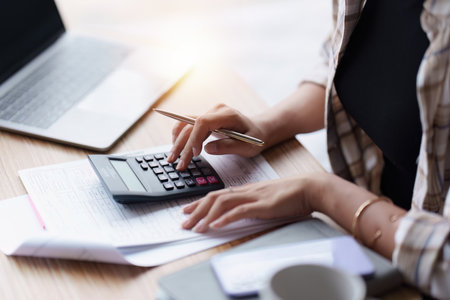 Asian accounting professional calculating household bills, reviewing and analyzing household bills, and filing tax returns.の写真素材
