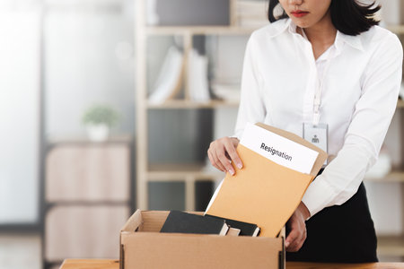 Resignation concept. Fired employee holding box of belongings in an officeの写真素材