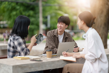 Beautiful young Asian people college student with friends at outdoors. College student working on the college campus.の写真素材