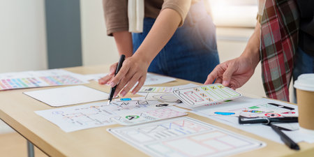Close up ux developer and ui designer brainstorming interface wireframe design.Creative digital...