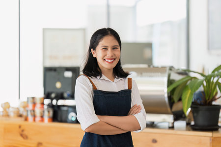 Asian cafe owner or barista standing with smiling at cafe. woman small business owner in food and beverageの写真素材